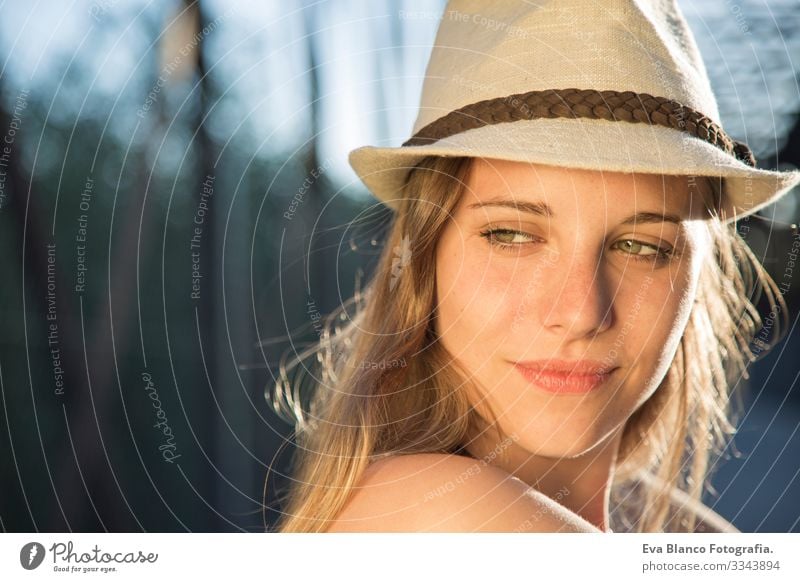 Porträt einer jungen Frau bei Sonnenuntergang Jugendliche Außenaufnahme Glück blond Hut blaue Augen Brücke Sommer Sonnenstrahlen Behaarung Fröhlichkeit