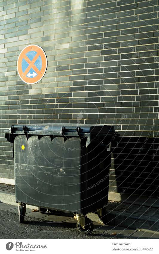 Müllbehälter Stadt Mauer Wand Straße Kunststoff Schilder & Markierungen Verkehrszeichen warten blau grau rot schwarz Asphalt Schatten Backstein Farbfoto