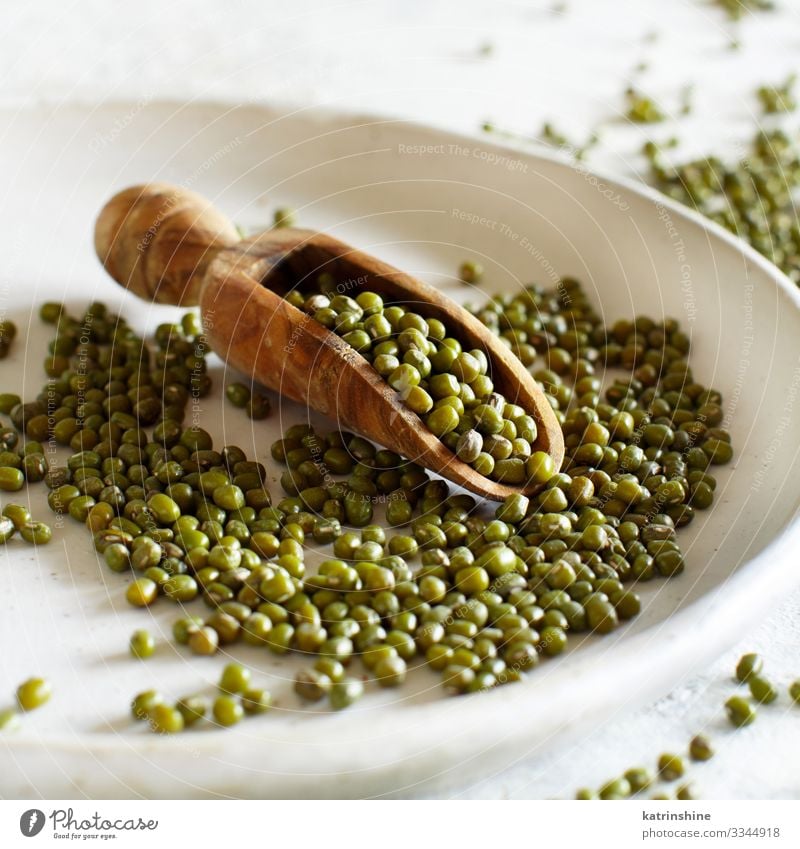 Getrocknete Mungbohnen mit einem Löffel auf einem Teller Vegetarische Ernährung Diät Tisch grün weiß Bohnen mung Details näher betrachten getrocknet Sehne