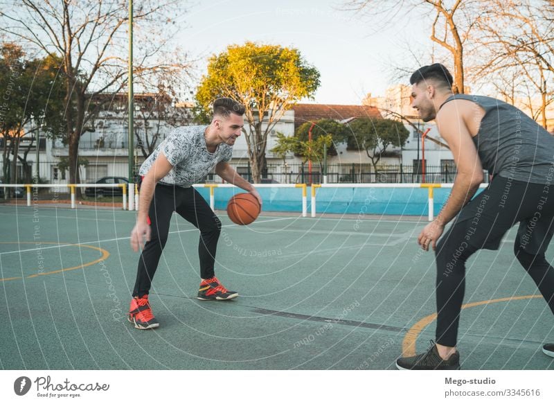 Zwei junge Freunde spielen Basketball. Lifestyle Freude Glück Erholung Freizeit & Hobby Spielen Sport Ball Mensch maskulin Junge Mann Erwachsene Freundschaft 2