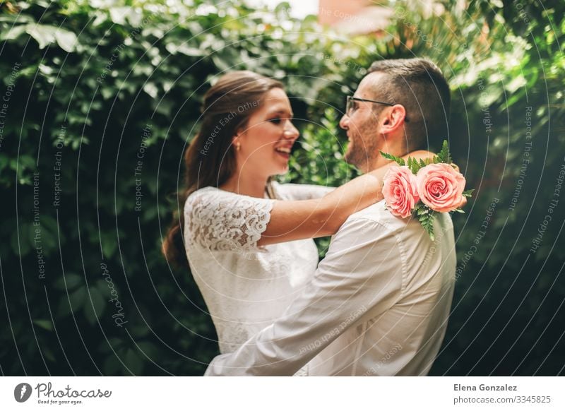 Frisch verheiratetes Paar, das sich gegenseitig umarmt und tanzt. Garten Feste & Feiern Hochzeit Frau Erwachsene Mann Rose Blumenstrauß Küssen Liebe Umarmen