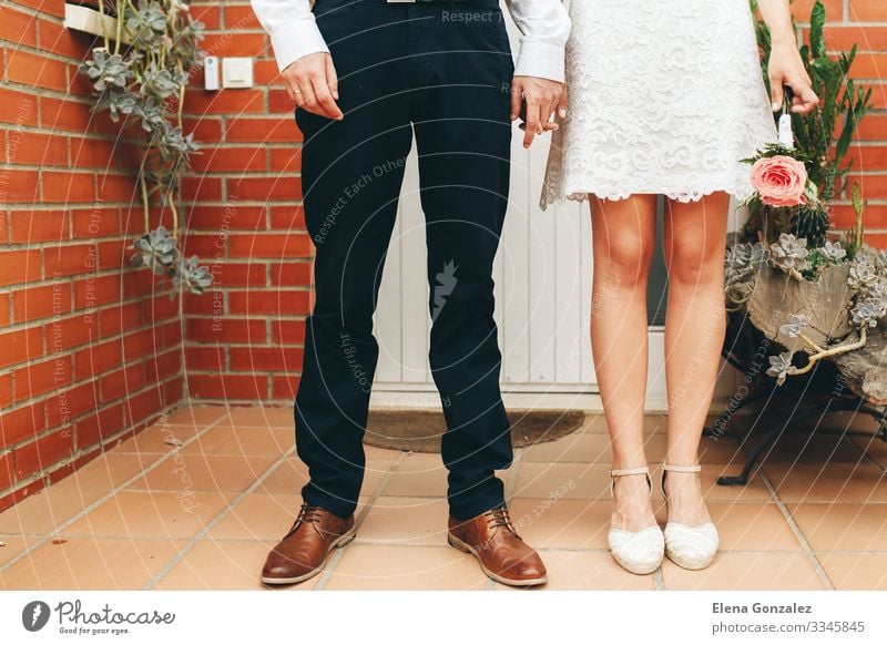 Die Schuhe des Bräutigams und der Braut und ihr kleiner Hochzeitsstrauß. Feste & Feiern feminin Frau Erwachsene Hand Rose Blumenstrauß Liebe Zusammensein