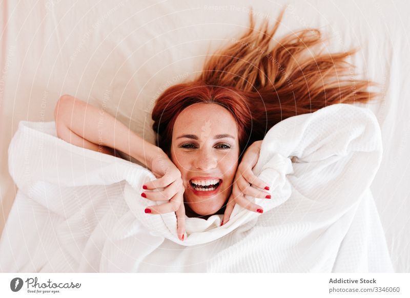 Positive Dame versteckt sich zu Hause unter einer Decke Frau Lügen Bett versteckend Morgen Sitzen Deckung Spaß unten sich[Akk] entspannen ruhen Lächeln genießen