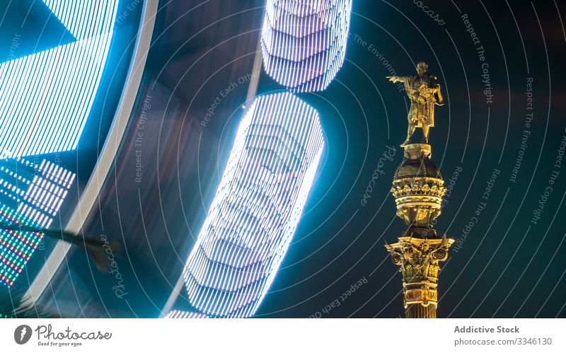 Von Lichtern und Statue beleuchtetes Riesenrad Architektur Illumination urban Großstadt Nacht Stadtbild Skyline Rad ferris Struktur Bewegung reisen Sightseeing