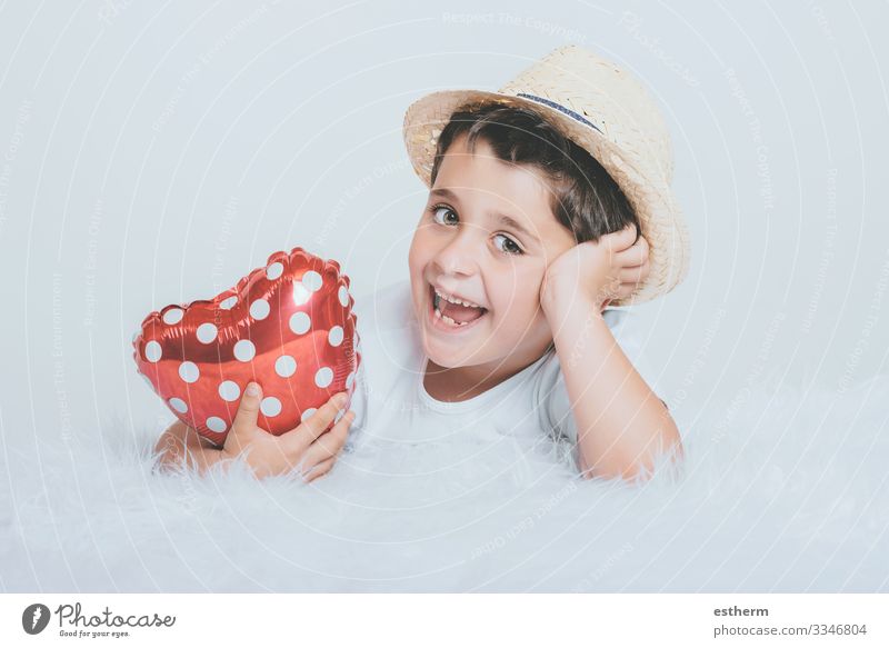 Lächelndes Kind mit einem herzförmigen Luftballon auf weißem Hintergrund Lifestyle Freude Gesundheitswesen Medikament Feste & Feiern Valentinstag Muttertag