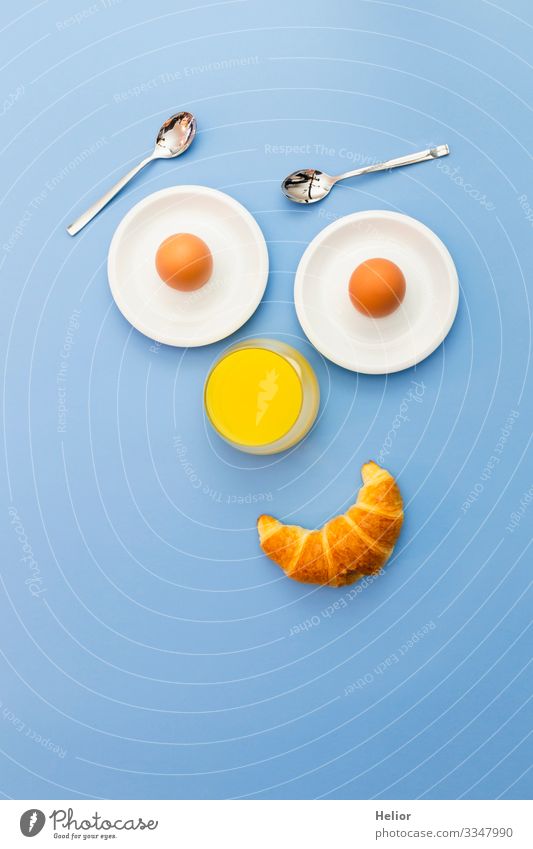 Lustiges Frühstückskonzept mit abstraktem menschlichem Gesicht Croissant Getränk Saft Teller Löffel Freude Erholung Essen androgyn Lächeln Blick Freundlichkeit