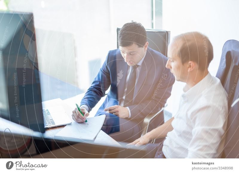 Bild von zwei Geschäftsleuten, die sich bei einem Treffen in einem modernen Handelsbüro über ein Bissigkeitsproblem unterhalten. Geschäftsleute sitzen im Sitzungssaal und besprechen den Geschäftsplan.