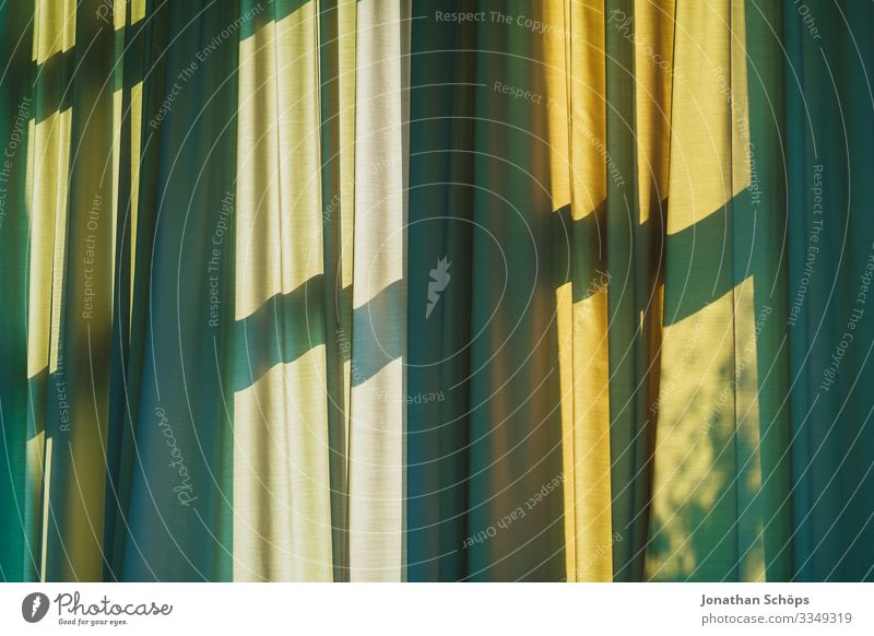 Vorhang mit Schatten vom Fenster Gardine grün gelb Fensterkreuz schattenspiel muster hintergrund falten sonnenlicht sonnenschutz warm sommer Licht Innenaufnahme
