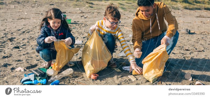 Junge Freiwillige reinigen den Strand Glück Camping Kind Internet Mensch Frau Erwachsene Mann Menschengruppe Umwelt Sand Kunststoff Lächeln dreckig Teamwork