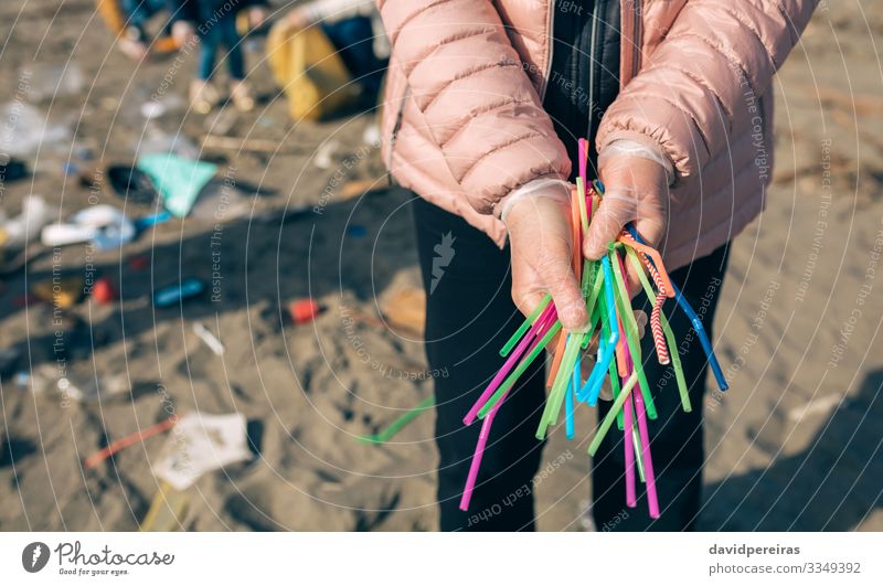 Frau zeigt eine Handvoll Strohhalme, die am Strand gesammelt wurden Trinkhalm Arbeit & Erwerbstätigkeit Mensch Erwachsene Familie & Verwandtschaft