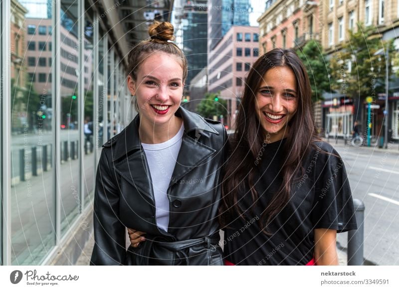 Porträt von zwei jungen Frauen, die Seite an Seite auf der Straße lächeln Lifestyle schön Erwachsene Jugendliche Fröhlichkeit Lebensfreude Liebe Junge Frauen