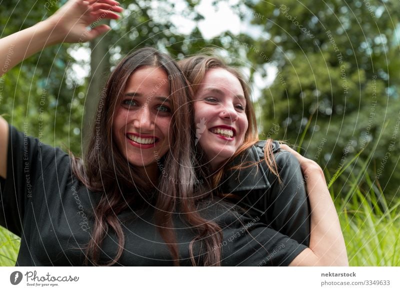 Mädchen aus dem Nahen Osten und dem Kaukasus umarmen und lächeln Freude schön Frau Erwachsene Freundschaft Jugendliche Natur Gras Lächeln Umarmen Fröhlichkeit
