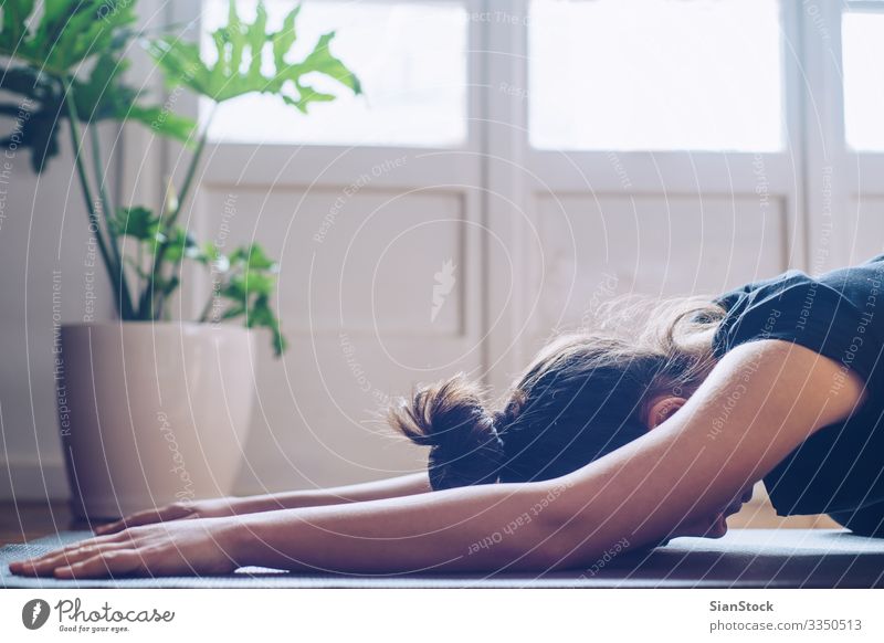 Frau, die morgens bei ihr zu Hause Yoga macht. Topf Lifestyle Glück schön Wellness Erholung Meditation Sport Kind Erwachsene Pflanze Blatt Fitness modern grün
