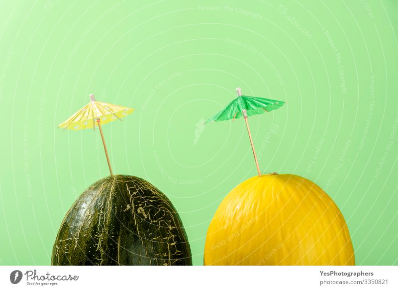 Zwei Melonen mit Cocktailschirm, Konzept für Sommermelonengetränke Frucht Dessert Bioprodukte lecker farbenfroh Entwurf Kürbisgewächse Diätnahrung