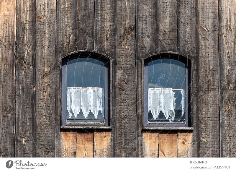 Kleine Fenster in einer Holzfasade Menschenleer Haus Hütte Bauwerk alt authentisch historisch niedlich braun schwarz Scheibengardienen Häkelgardienen gehäkelt