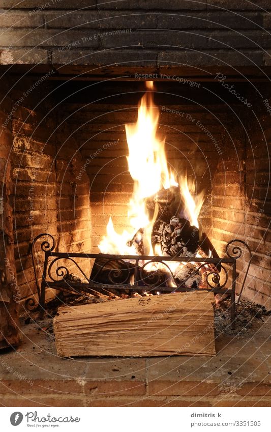 Feuer in einem alten Kamin mit verkohlten Ziegeln brennen Winter Metall Backstein dreckig schwarz Feuerstelle Holz brennend Flamme erwärmen Herd Brandasche