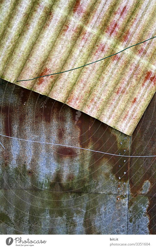 Zwei alte, dreckige Wellbleche auf einer Baustelle mit gespanntem Draht davor, liegen in einem alten Garten als Müll. Blech Wand Mauer Strukturen & Formen