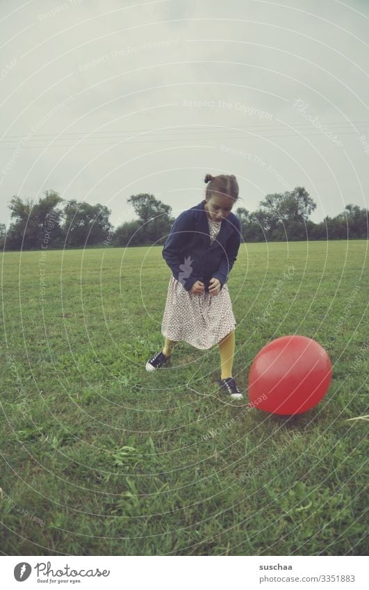 mädchen mit einem roten luftballon auf einer wiese Kind Mädchen Kindheit Wiese Luftballon spielen altmodisch retro Außenaufnahme Gras Umwelt Feld Freude