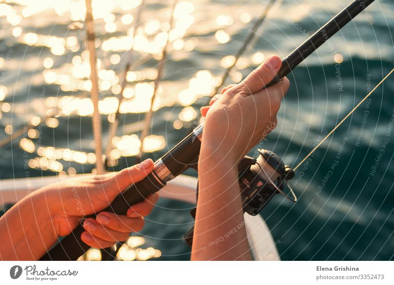 Weibliche Hände halten eine Angelrute zum Fischen. Lifestyle Erholung Freizeit & Hobby Angeln Ferien & Urlaub & Reisen Ausflug Meer Entertainment Frau