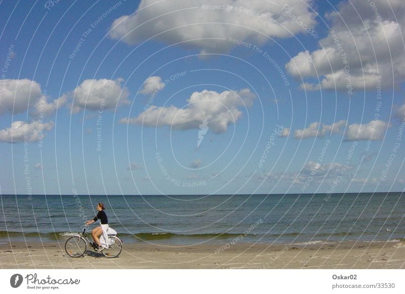 Fahrrad am Strand Frau Meer Wolken