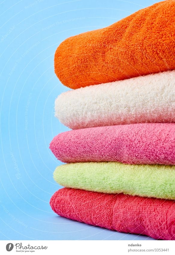 Stapel gefaltete Handtücher aus farbigem Baumwollfrottee Lifestyle Design Körper Erholung Spa Massage Stoff frisch modern neu Sauberkeit weich blau grün rosa