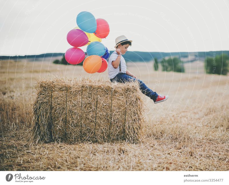 Kind mit Luftballons im Weizenfeld im Freien Lifestyle Erholung Ferien & Urlaub & Reisen Freiheit Sommer Mensch maskulin Junge 1 3-8 Jahre Kindheit Natur