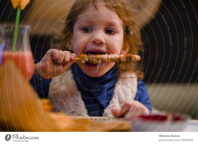 Das kleine blonde Mädchen isst gerne Kebab. Zeit für das Abendessen. Blick in die Kamera Innenaufnahme Speise Essenszeit Genuss geschmackvoll Mahlzeit