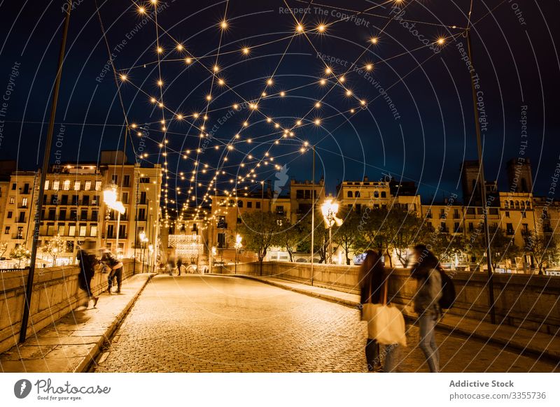 Menschen gehen abends auf einer beleuchteten Brücke in der Stadt laufen Illumination Großstadt Lehnen urban Architektur Abend Gebäude Nacht Dämmerung