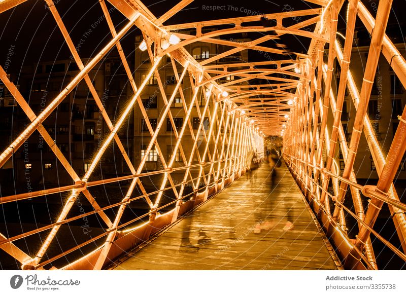 Menschen gehen abends auf beleuchteter Brückenkonstruktion Konstruktion laufen Illumination Großstadt Lehnen urban Architektur Abend Gebäude Nacht Dämmerung