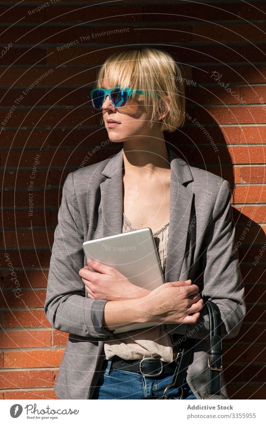 Geschäftsfrau mit Tablette an der Wand stylisch jung Frau Lehnen Backsteinwand professionell Person schön attraktiv Sonnenbrille Wegsehen Unternehmer elegant