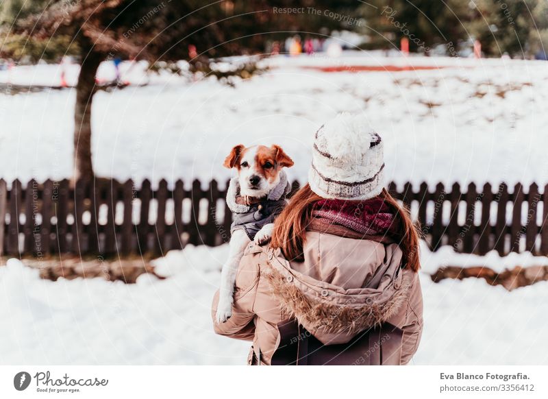 Frau, die ihren süßen Jack-Russell-Hund auf der Schulter hält. Wintersaison am Berg Spielen Schneebälle Berge u. Gebirge Außenaufnahme Ferien & Urlaub & Reisen
