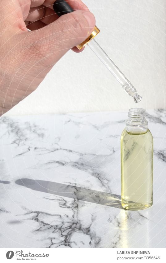 Pipettiertes Öl in Glasflasche auf Marmor Flasche Körper Haut Behandlung Medikament Duft Spa Wissenschaften Labor Container Tropfen natürlich braun weiß
