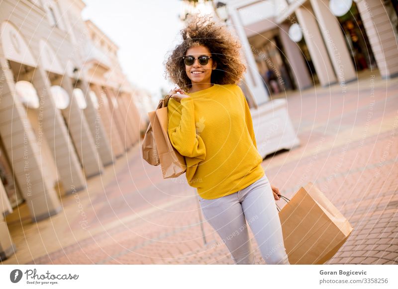 Junge schwarze Frau mit lockigem Haar beim Einkaufen Lifestyle Stil Glück schön Haare & Frisuren Mensch Junge Frau Jugendliche Erwachsene 1 18-30 Jahre Straße