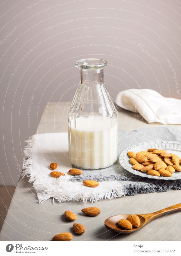 Mandelmilch in einer Glasflasche auf einem Tisch Lebensmittel Ernährung Frühstück Bioprodukte Vegetarische Ernährung Diät Getränk Milch Flasche Lifestyle