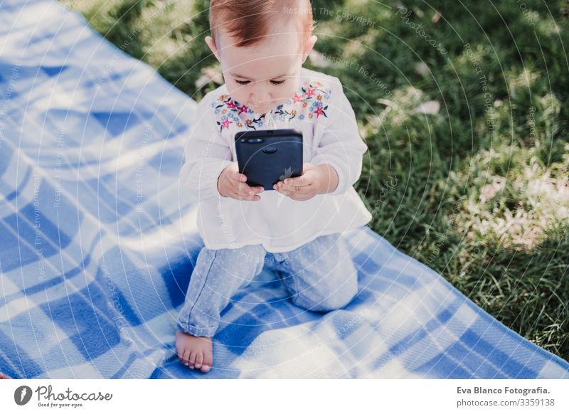 glückliches Baby, das sein Handy im Freien benutzt. technologiekonzept Mutter Technik & Technologie Zusammensein Kind Kindererziehung Mädchen Freude
