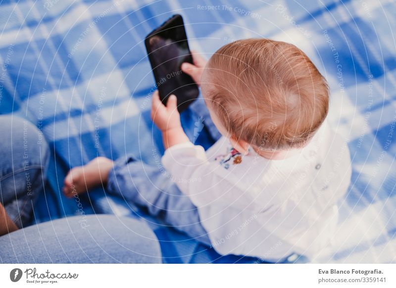 junge Mutter und glückliches Baby, das im Freien mit dem Handy telefoniert. technologiekonzept Technik & Technologie Zusammensein Kind Kindererziehung Mädchen