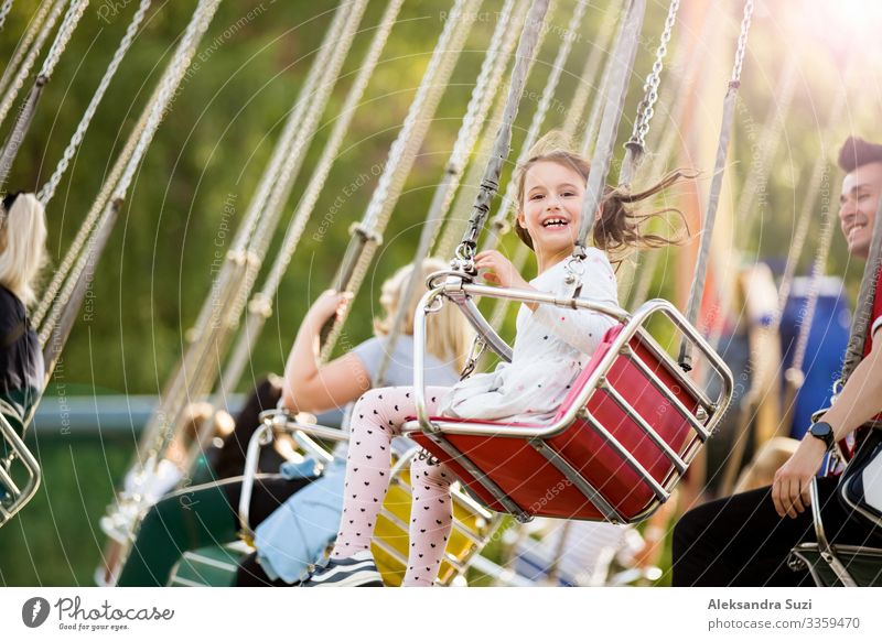 Kleines Mädchen mit Spaß auf dem Kettenkarussell. Glückliche Sommer-Erinnerungen. Unbeschwerte Kindheit und Glück Aktion Aktivität Abenteuer Vergnügen schön