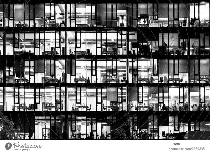beleuchtete Büros eines Hochhauses am Abend - Feierabend Büroarbeit Bankgebäude Fassade Hauptstadt Fenster Stuhl Schreibtisch Schrank Computer
