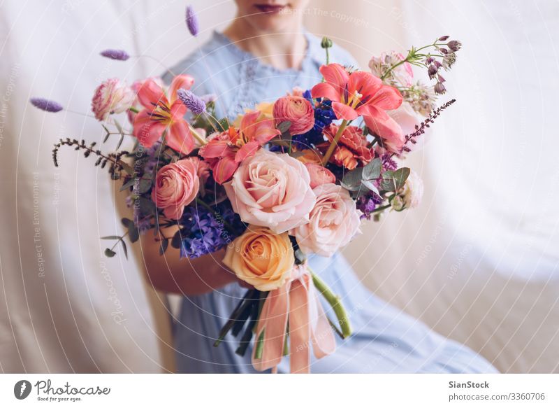 Junge Frau in einem hellblauen Kleid mit einem Blumenstrauß in der Hand. Lifestyle elegant Stil Glück schön Stuhl Hochzeit Erwachsene Lippen brünett sitzen