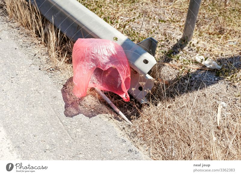 Elegantly wasted -IV- kaufen Reichtum Umwelt Natur Sträucher Straßenrand Verpackung Plastiktüte Müll Leitplanke fliegen hängen trashig trist rosa rot