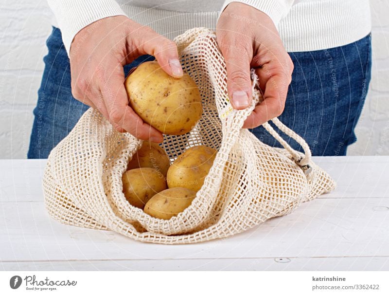 Frau legt frische Kartoffeln in einen Textilbeutel Lebensmittel Gemüse Lifestyle kaufen Erwachsene Hand Umwelt Kunststoff frei natürlich weiß