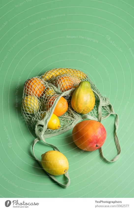 Reife tropische Früchte in einer Netz-Einkaufstasche. Früchte kaufen Frucht Orange Gesunde Ernährung grün obere Ansicht farbenfroh Diätnahrung