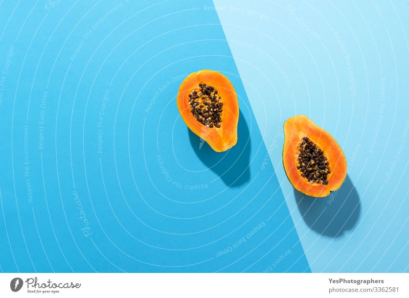 Frische Papayafrüchte halbiert auf blauem Hintergrund Frucht Dessert Bioprodukte Gesunde Ernährung saftig obere Ansicht Blauer Hintergrund blaue Farbtöne