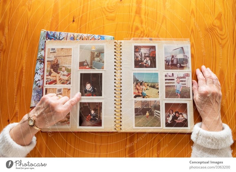 Draufsicht einer älteren kaukasischen Frau, die sich ein altes Fotoalbum anschaut Themen von Erinnerungen Nostalgie Fotos im Ruhestand Senior Album Bild Ehefrau