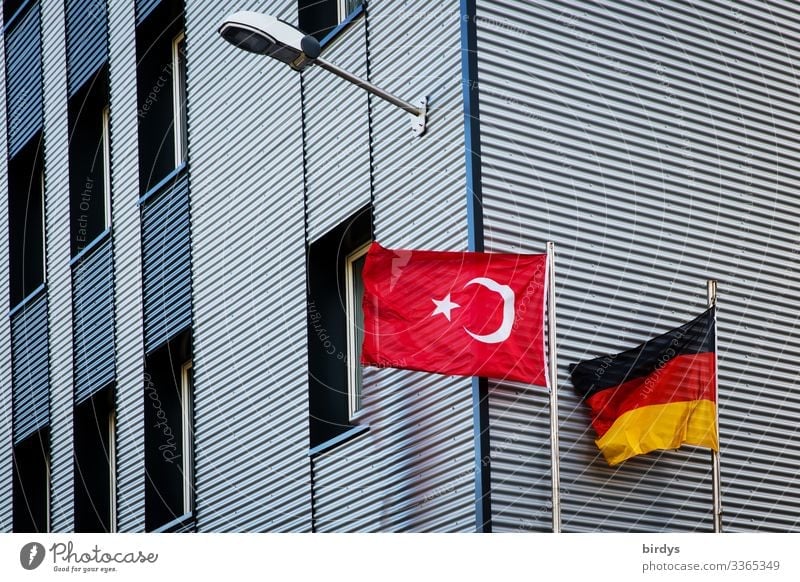 Deutschlandfahne und Türkeifahne wehen gemeinsam im Wind vor einem Gebäude türkische Flagge Deutsche Flagge Hochhaus Moschee Integration Politik & Staat