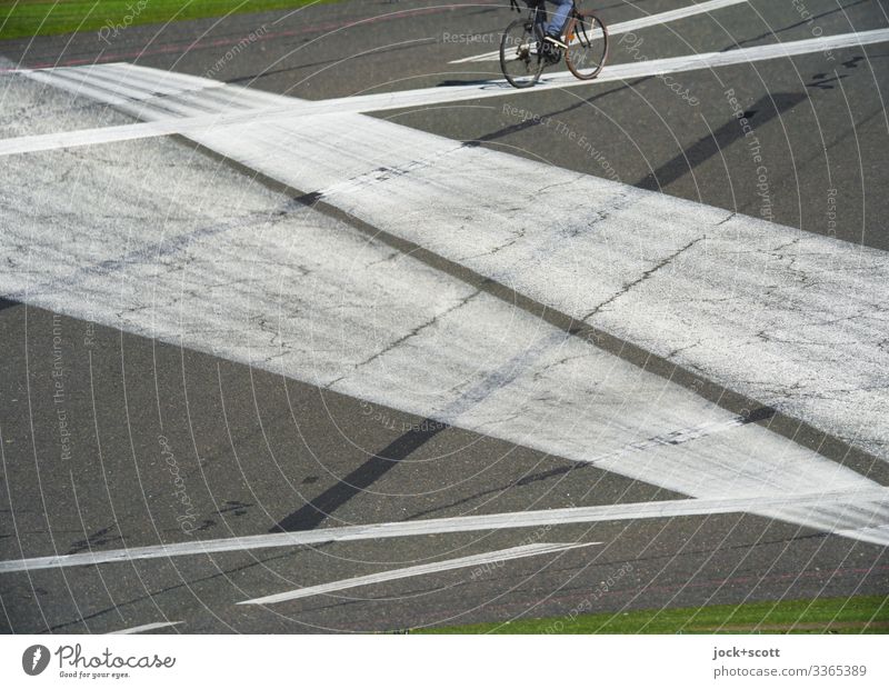 Radfahrer erscheint auf der Linie vom Flugplatz Doppelbelichtung Linien Experiment Landebahn Mobilität Freizeit Strukturen & Formen Freizeit & Hobby