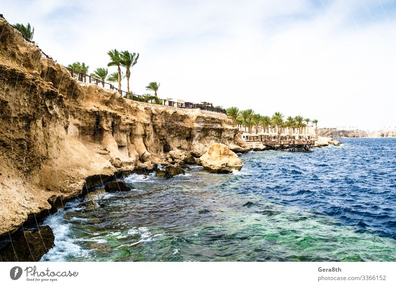 Blick vom Meer auf einen Felsstrand und ein Riff am Roten Meer Ferien & Urlaub & Reisen Wellen Himmel Küste Korallenriff Stein blau gelb Ägypten Rotes Meer