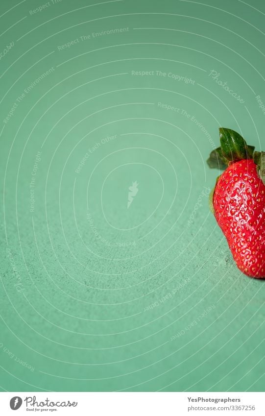 Eine Erdbeere auf grünem Tisch. Teil einer Nahaufnahme einer Erdbeere Frucht Dessert Bioprodukte Vegetarische Ernährung Diät frisch natürlich niedlich süß rot