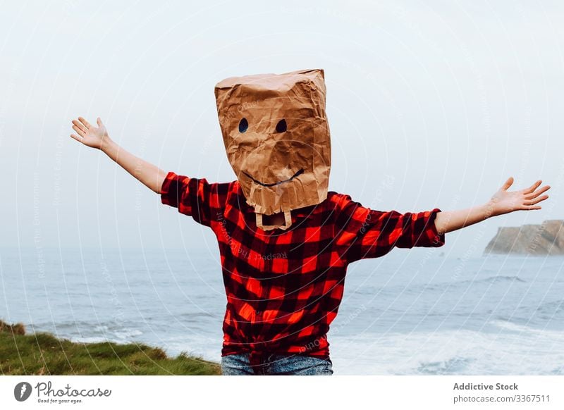 Person mit Papiertüte auf dem Kopf, die an Land springt Kunststoff Paket Ökologie Tüte Konzept Umwelt gestikulieren Zeichen Natur Verschmutzung Tasche