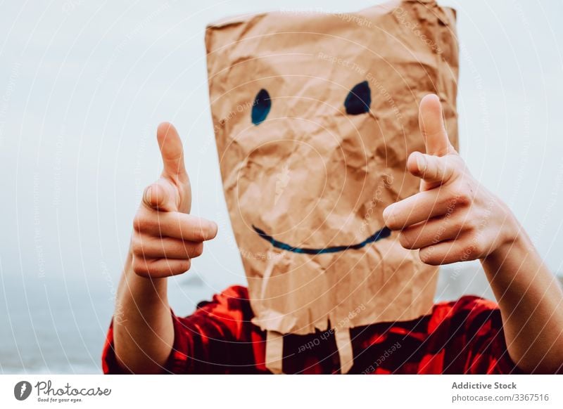 Person mit Papiertüte am Kopf, die auf die Kamera zeigt Kunststoff Paket Ökologie Tüte Konzept Zeigen Umwelt gestikulieren Zeichen Natur Verschmutzung Tasche